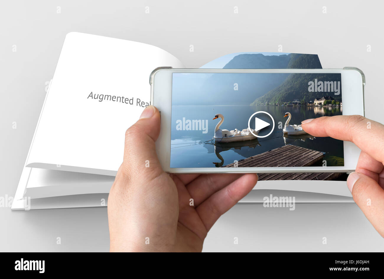 Augmented reality marketing concept. Hand holding smart phone use AR application to play video for customer. Stock Photo