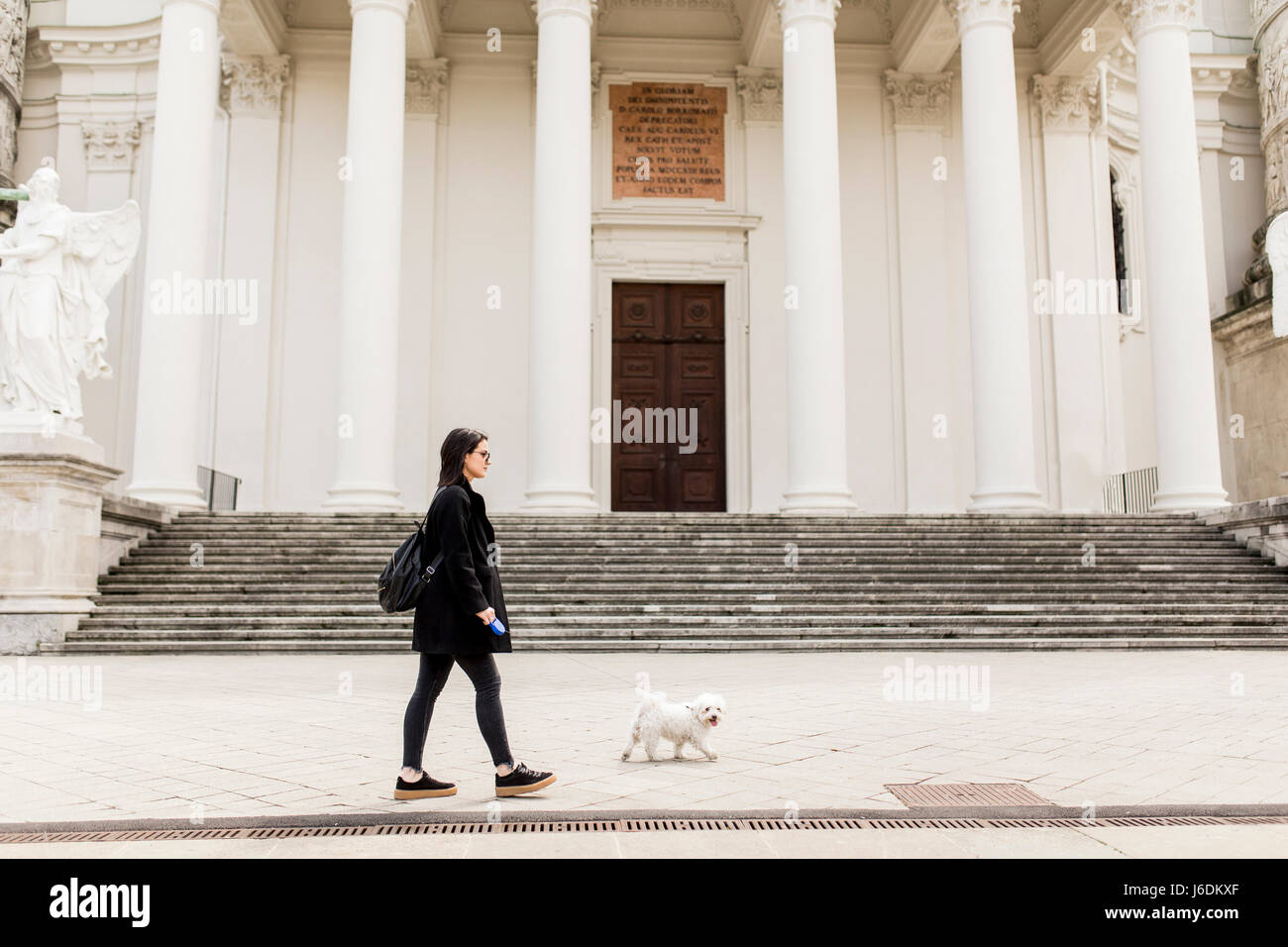 Young woman walking with a dog on the street Stock Photo - Alamy