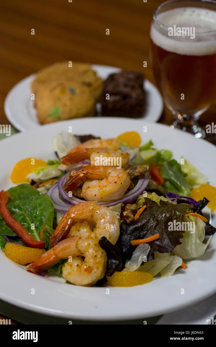 Lunch, Mandarin orange shrimp salad with candied walnuts, cookies and beer. Stock Photo