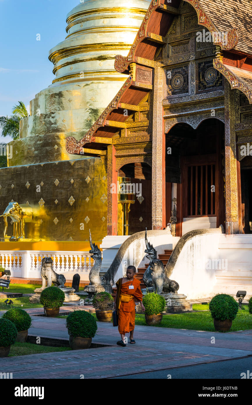 Young Thai monk walking in front of Wat Phra Singh Stock Photo