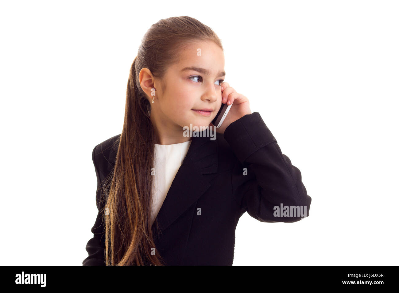 Little girl in black jacket talking on the phone  Stock Photo