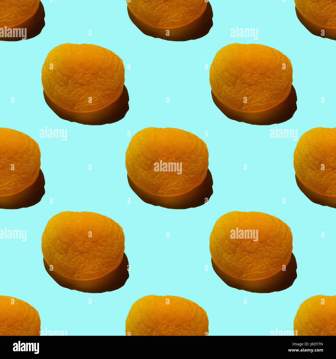 Seamless pattern of dried apricots isolated on light turquoise