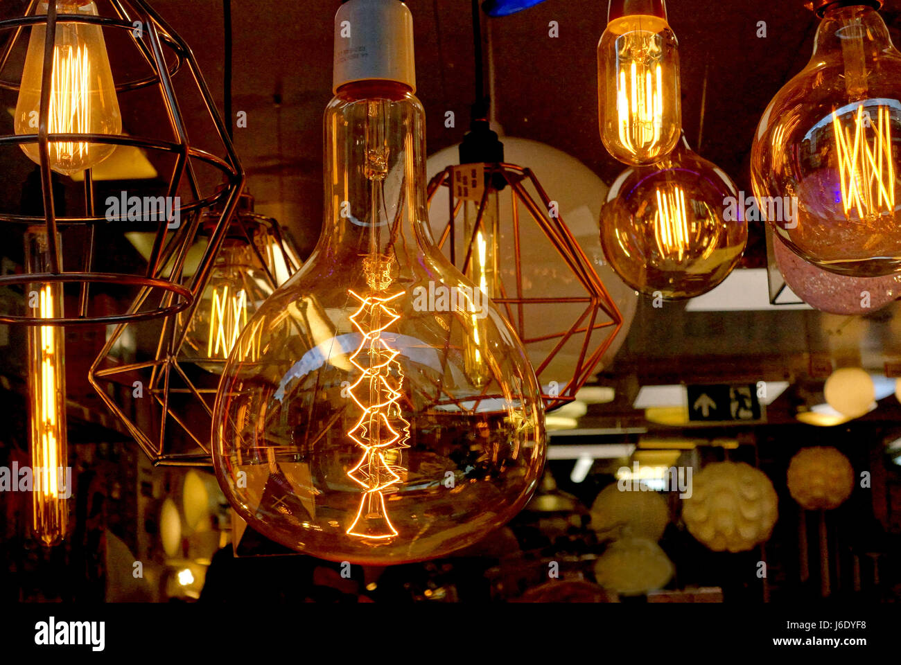 Glowing filaments in oversized light bulbs in shop window display, London Stock Photo