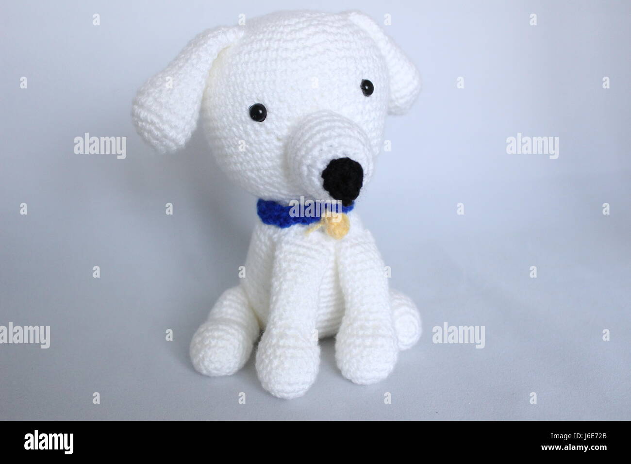 White dog toy hand-crocheted posed on white background Stock Photo