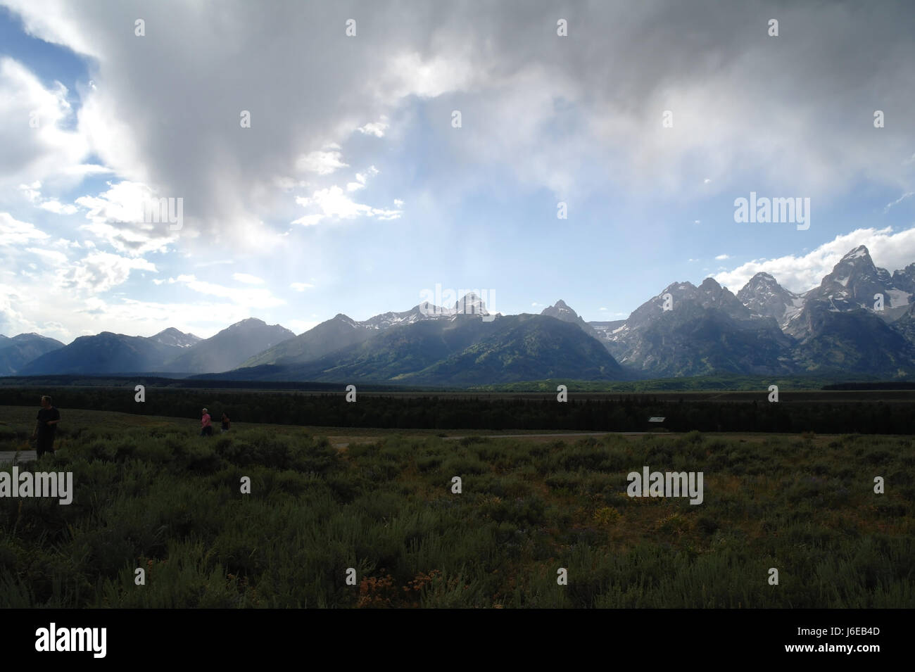 Blue sky grey rain shower clouds view Grand Teton and southern Teton peaks from Glacier View Turnout, Jackson Hole, Wyoming, USA Stock Photo