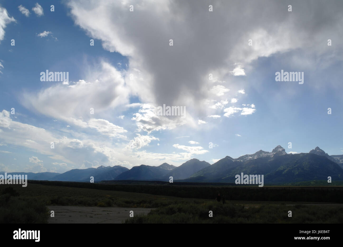 Blue sky grey shower cloud over Jackson Hole and Teton Mountains from Mount Wister to Mount Glory and beyond, south from Glacier View Turnout, Wyoming Stock Photo