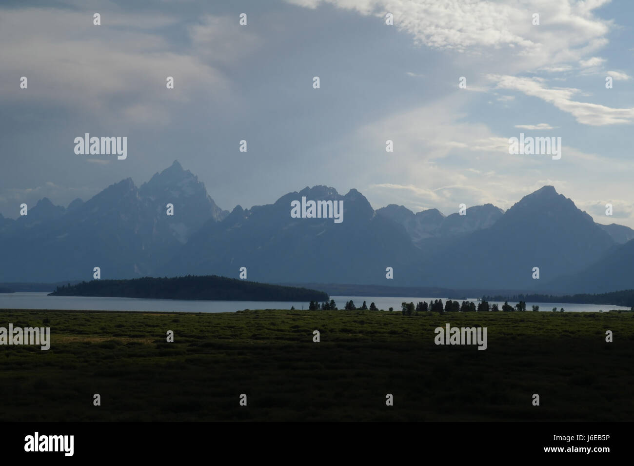 Grey clouds summer evening view across Jackson Hole and jackson Lake to Teton peaks, looking south from Jackson Lake Lodge, Wyoming, USA Stock Photo