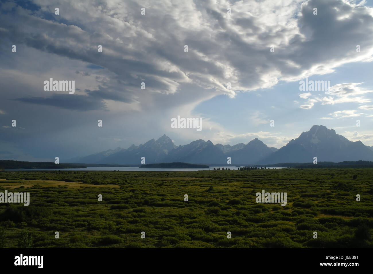 Blue sky evening view stratocumulus clouds over sagebrush Jackson Hole valley-floor and Teton Mountains, south from Jackson Lake Lodge, Wyoming, USA Stock Photo