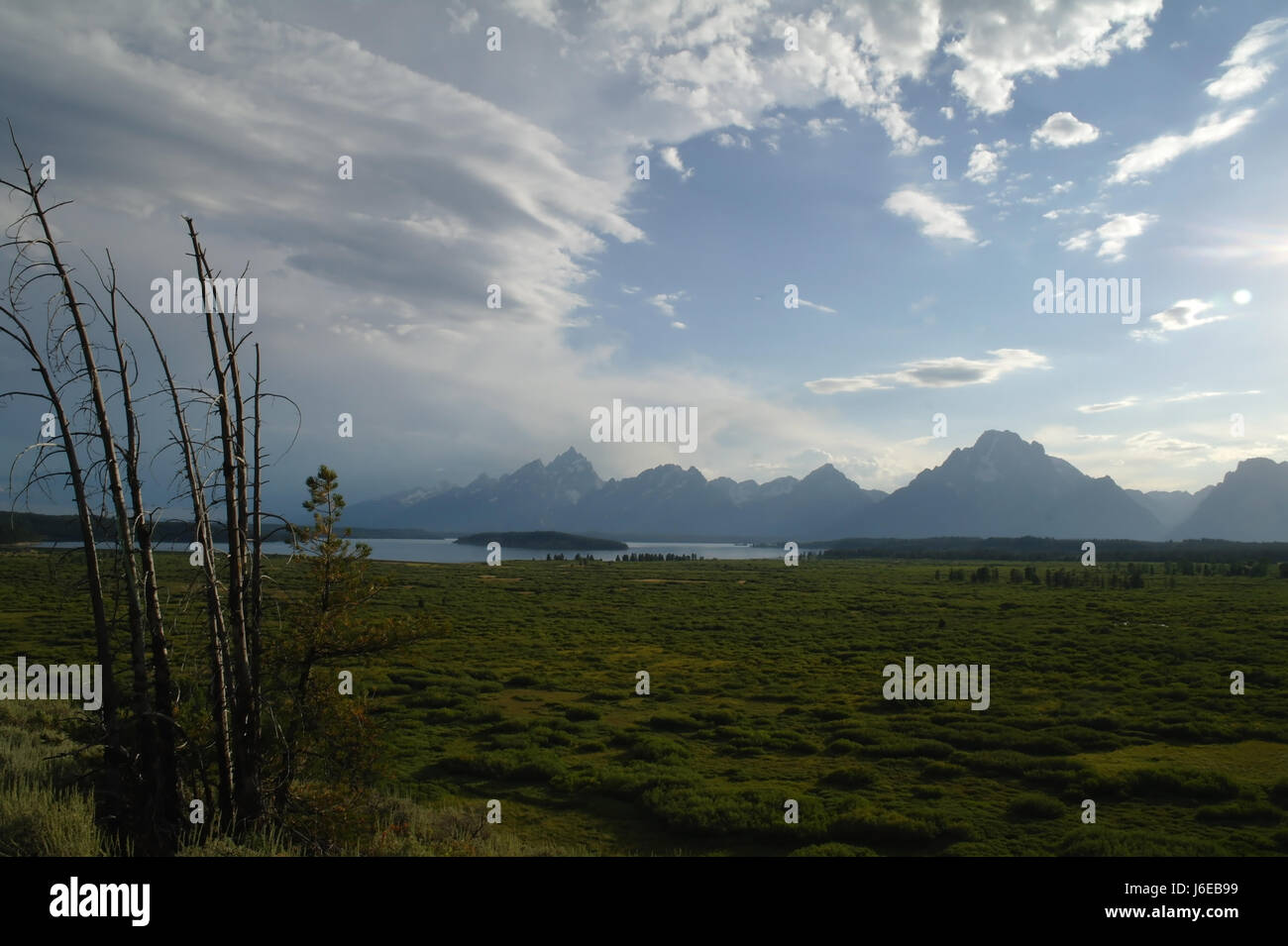 Blue sky view stratocumulus clouds over Jackson Hole to Jackson Lake and Teton Mountains, looking south from Jackson Lake Lodge footpath, Wyoming, USA Stock Photo