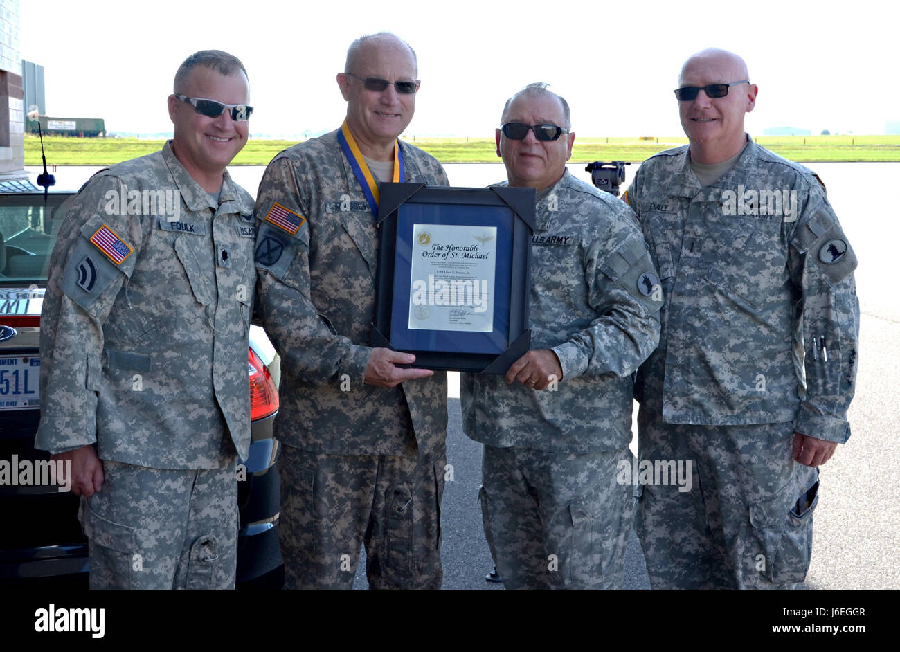 Maj. Gen. Frank Vavala, Lt. Col. Brian Foulk, and Chief Warrant Officer 5  Dave Dale present Chief Warrant Officer 5 Lloyd Massey with The Honorable  Order of St. Michael on August 12,
