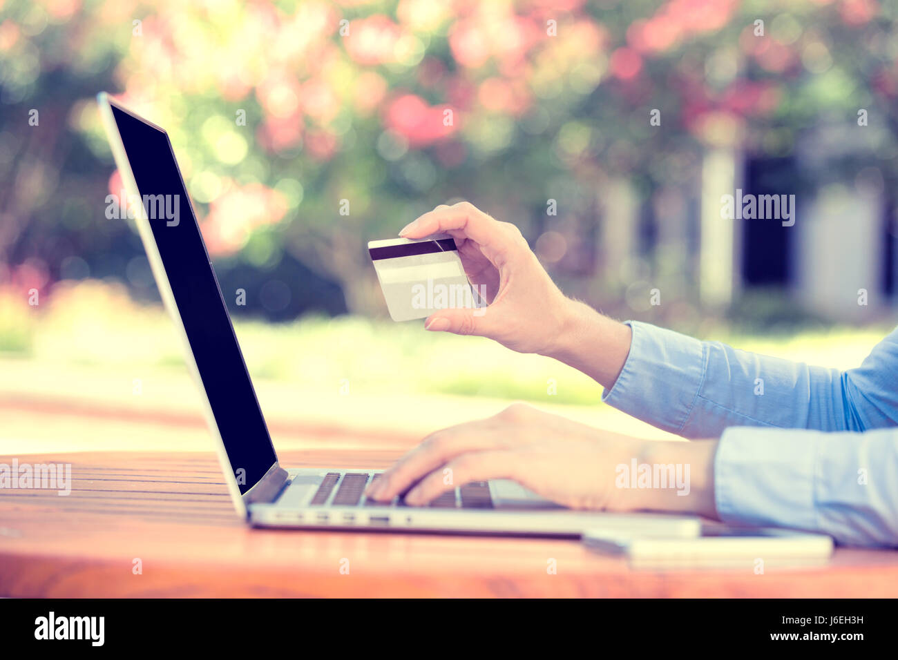 Closeup young woman hands holding credit card and using computer laptop for online shopping or reporting lost card, fraudulent transaction, isolated c Stock Photo