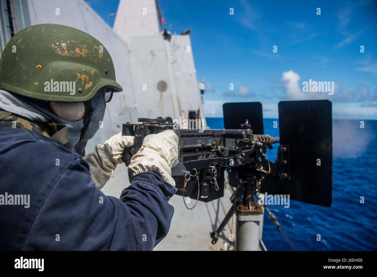 160812-N-XM324-375 WATERS OUTSIDE OF OKINAWA (Aug. 12, 2016) Operations Specialist 2nd Class Jeffrey Joseph, from New Orleans, fires a .50-caliber machine gun from the amphibious transport dock ship USS Green Bay (LPD 20). Green Bay, part of the Bonhomme Richard Expeditionary Strike Group, is operating in the U.S. 7th Fleet area of operations in support of security and stability in the Indo-Asia-Pacific region. (U.S. Navy photo by Mass Communication Specialist 3rd Class Patrick Dionne/Released) Stock Photo