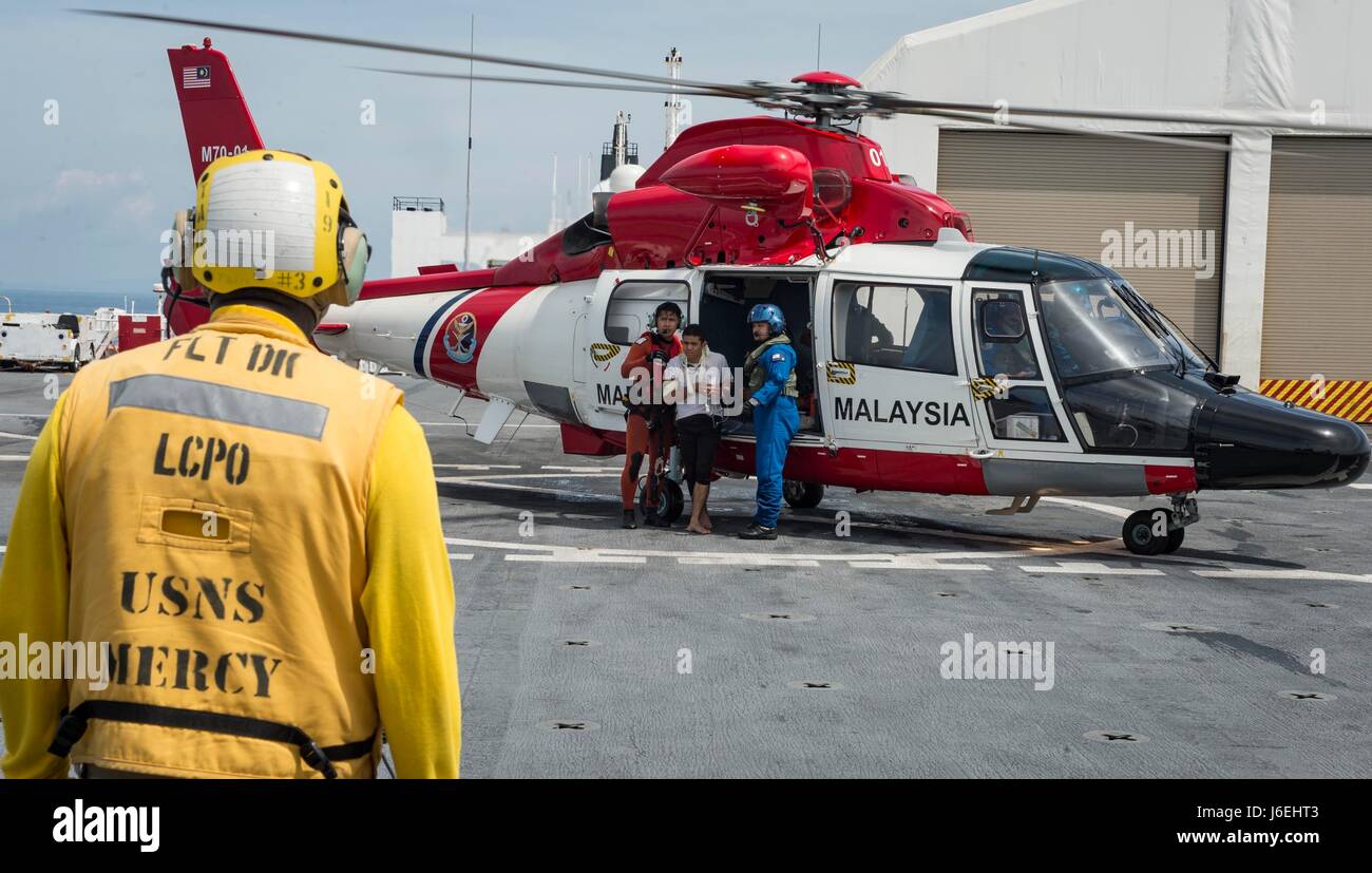 160814-N-QW941-210 AT SEA (Aug. 14, 2016) Chief Aviation Boatswain's Mate (Handling) Gerry Elam, a native of Longview, Texas, stands by as A Malaysian Maritime Enforcement Agency (MMEA) H-65 Dauphin helicopter, deploys a search and rescue swimmer while a Royal Malaysian Navy patrol vessel responds to a vessel in distress during a Pacific Partnership 2016 search and rescue exercise. During the exercise, Pacific Partnership and Malaysian Armed Forces personnel received, processed and treated five patients flown in by the MMEA H-65 Dauphin helicopter aboard USNS Mercy (T-AH 19). This event conclu Stock Photo