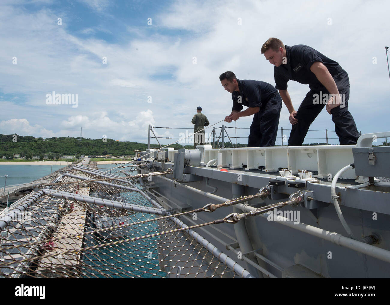 160817-N-NB544-025 OKINAWA, Japan (Aug. 17, 2016) Boatswain's Mate 3rd Class Christopher Schwall (left), from Chicago, mans a line as Seaman Allen Knight, from Streetman, Texas, observes line handlers on the pier as amphibious assault ship USS Bonhomme Richard (LHD 6) arrives at White Beach Naval Facility in Okinawa, Japan. During the visit, Bonhomme Richard will embark Marines of the 31st Marine Expeditionary Unit (MEU). Bonhomme Richard, flagship of the Bonhomme Richard Expeditionary Strike Group, is operating in the U.S. 7th Fleet area of operations in support of security and stability in t Stock Photo