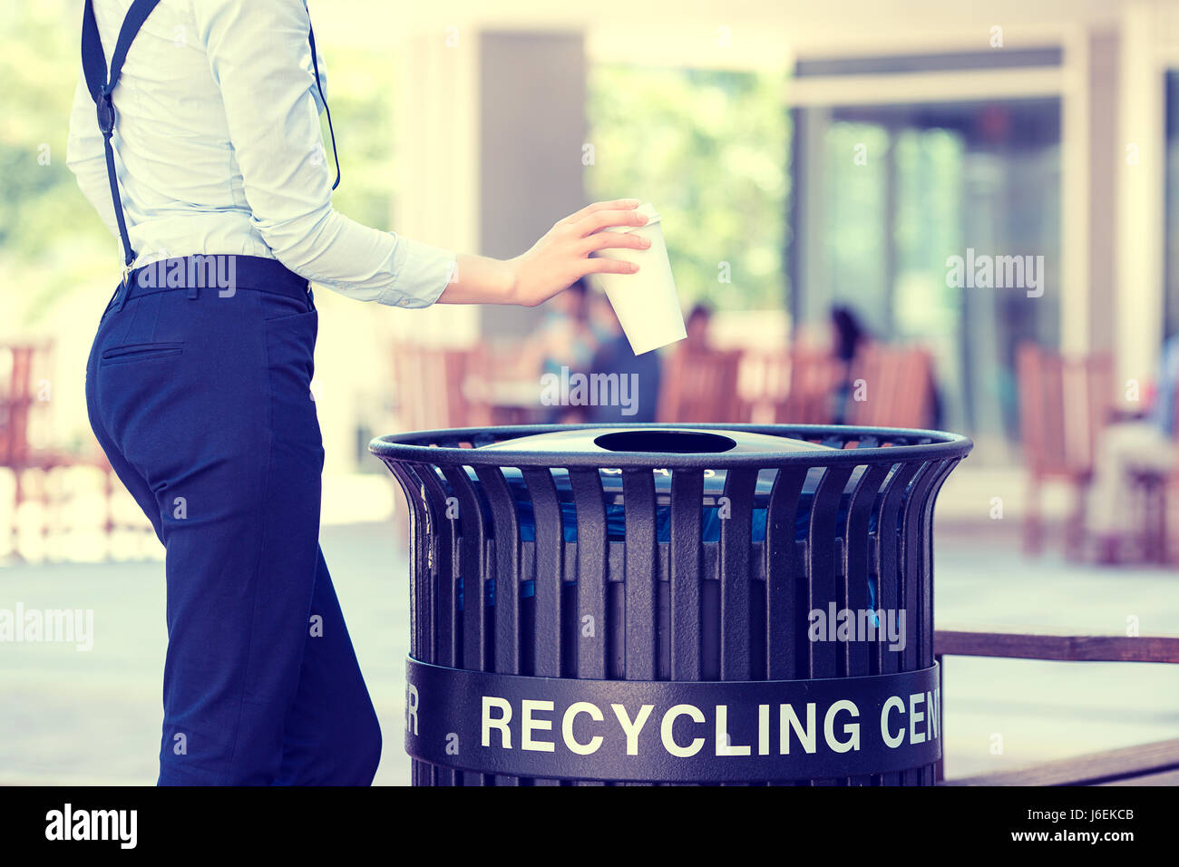 Closeup cropped image woman's hand throwing empty paper coffee cup in ...