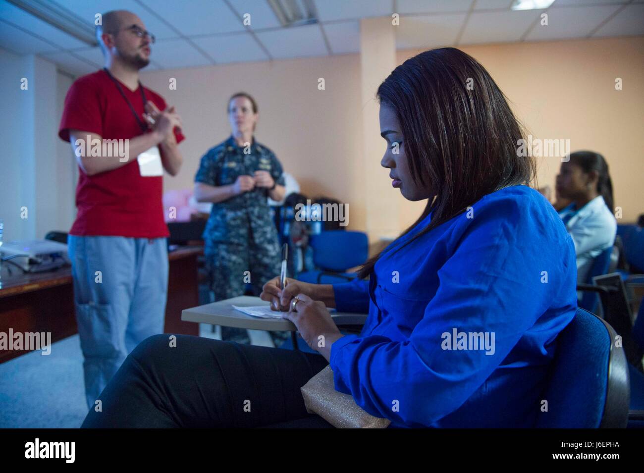 170324-N-YL073-164 RIOHACHA, Colombia (March 24, 2017) - A Colombian health professional takes notes during a discussion on violence against women lead by Lt. Cmdr. Carolyn Ellison, a native of Lenoir, N.C., assigned to Naval Hospital Pensacola, Fla., at a Riohacha hospital during Continuing Promise 2017's (CP-17) visit to Mayapo, Colombia. CP-17 is a U.S. Southern Command-sponsored and U.S. Naval Forces Southern Command/U.S. 4th Fleet-conducted deployment to conduct civil-military operations including humanitarian assistance, training engagements, and medical, dental, and veterinary support i Stock Photo