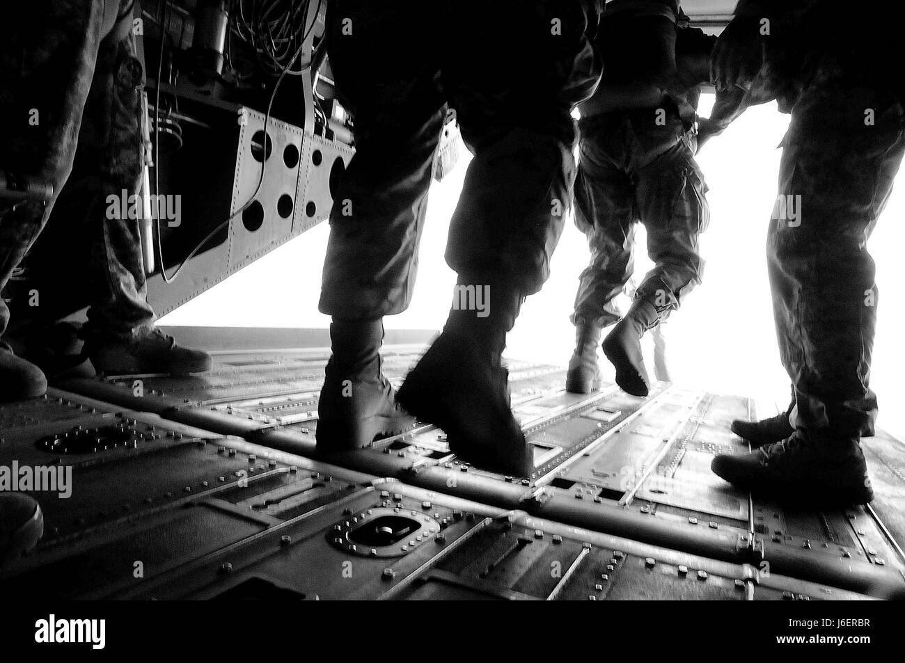 Rigger Course students jump from the rear ramp of a Chinook helicopter ...