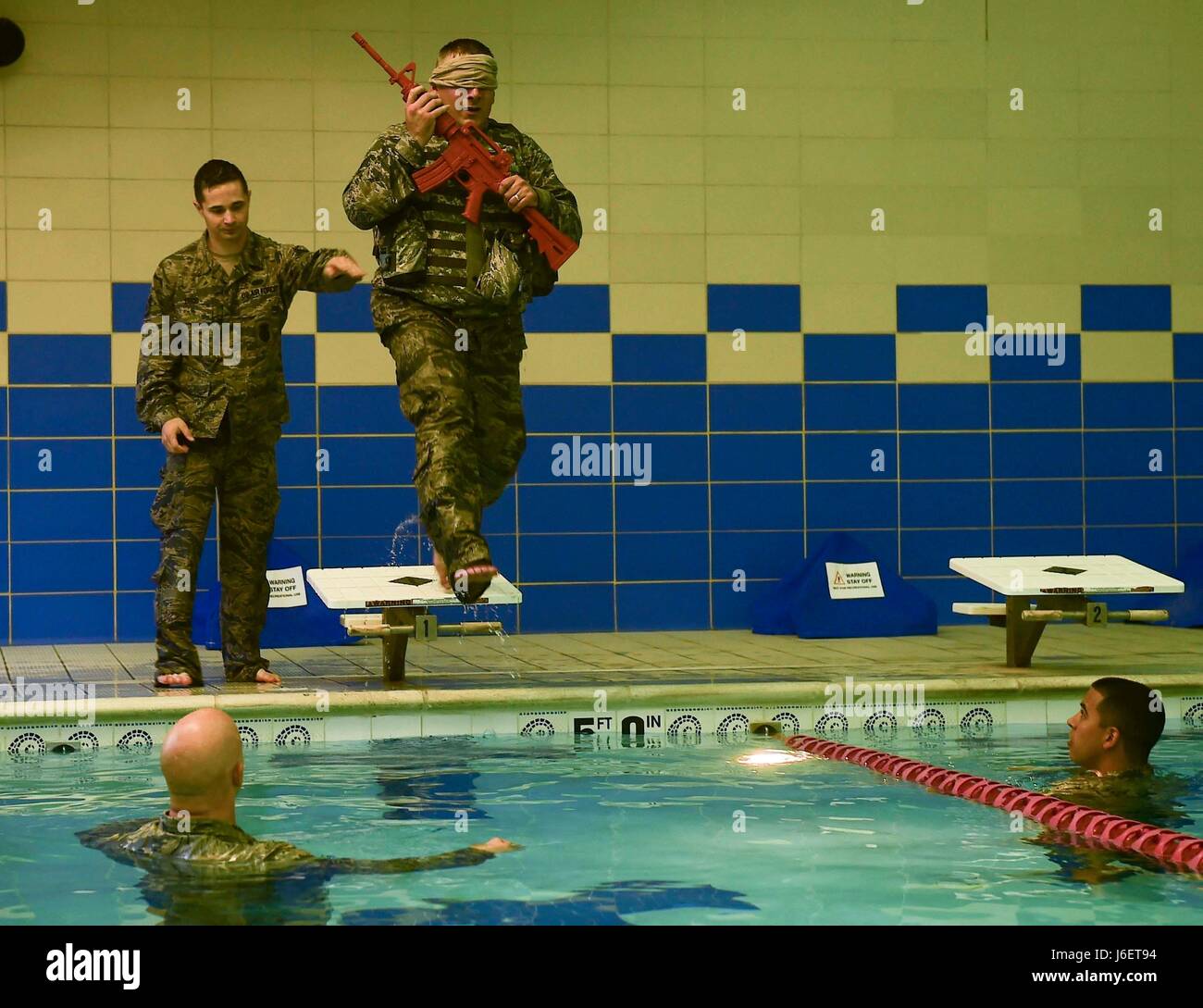 U.S. Air Force Tech. Sgt. Daniel Day, 633rd Security Forces flight chief, conducts water confidence training during a training evaluation at Joint Base Langley-Eustis, Va., April 28, 2017. To accomplish this training evolution, Day had to strip-off his combat vest and recover his weapon after jumping into the Shellbank Fitness Center pool blindfolded. (U.S. Air Force photo/Senior Airman Derek Seifert) Stock Photo