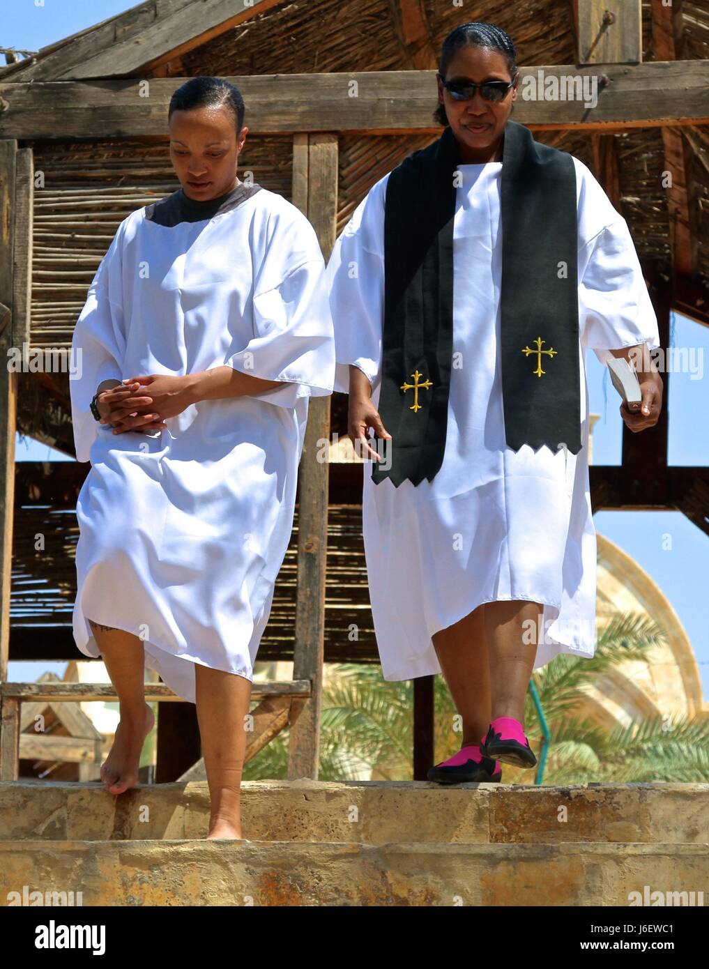 Staff Sgt. Christal Crawford, left, a USARCENT broadcast specialist, walks down the stairs leading to the Jordan River with Maj. Pinkie Fischer, USARCENT operations chaplain, at the baptism site of Jesus, May 5, 2017. Stock Photo