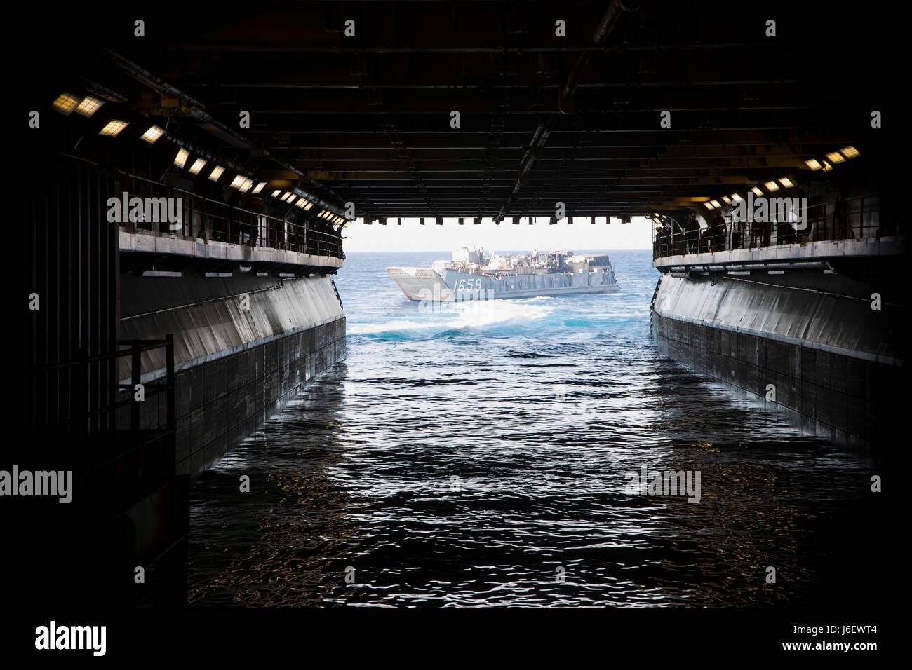 A landing craft utility departs the well deck of the amphibious assault ...