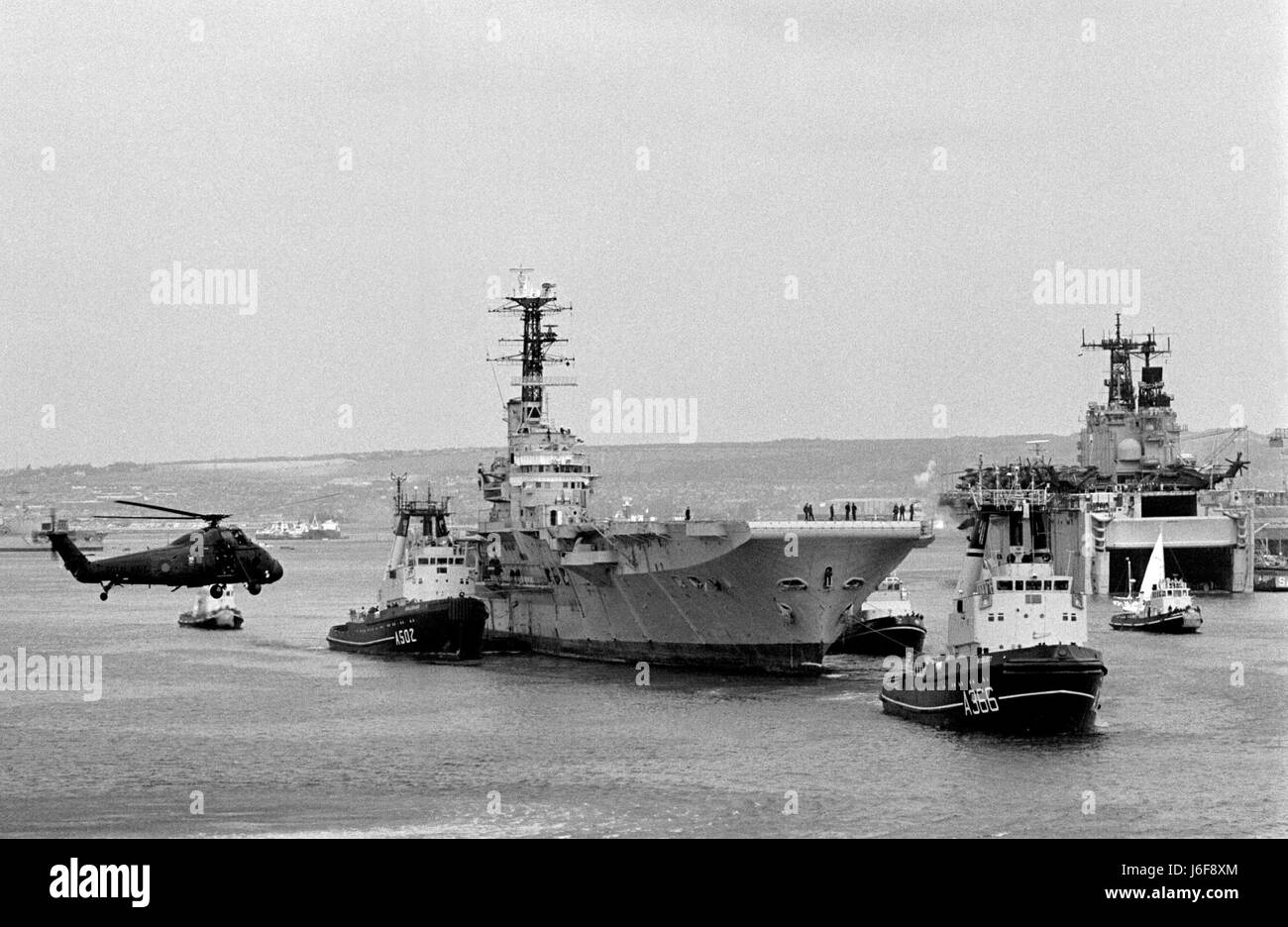 AJAXNETPHOTO. 1982. PORTSMOUTH, ENGLAND. - HMS BULWARK BEING TOWED OUT OF HARBOUR TO BE SCRAPPED.  PHOTO:JONATHAN EASTLAND/AJAX.  REF:100484 19A. Stock Photo