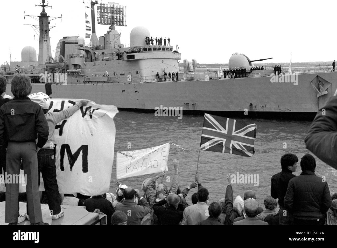 AJAXNETPHOTO. 19TH JUNE, 1982 - PORTSMOUTH, ENGLAND. - FALKLANDS VETERAN - SHEFFIELD CLASS (TYPE 42/1&2) DESTROYER HMS GLASGOW GETS A HEROES WELCOME AS THE BOMB DAMAGED SHIP RETURNED HOME FROM THE SOUTH ATLANTIC.  PHOTO:JONATHAN EASTLAND/AJAX.  REF:821906 19 Stock Photo