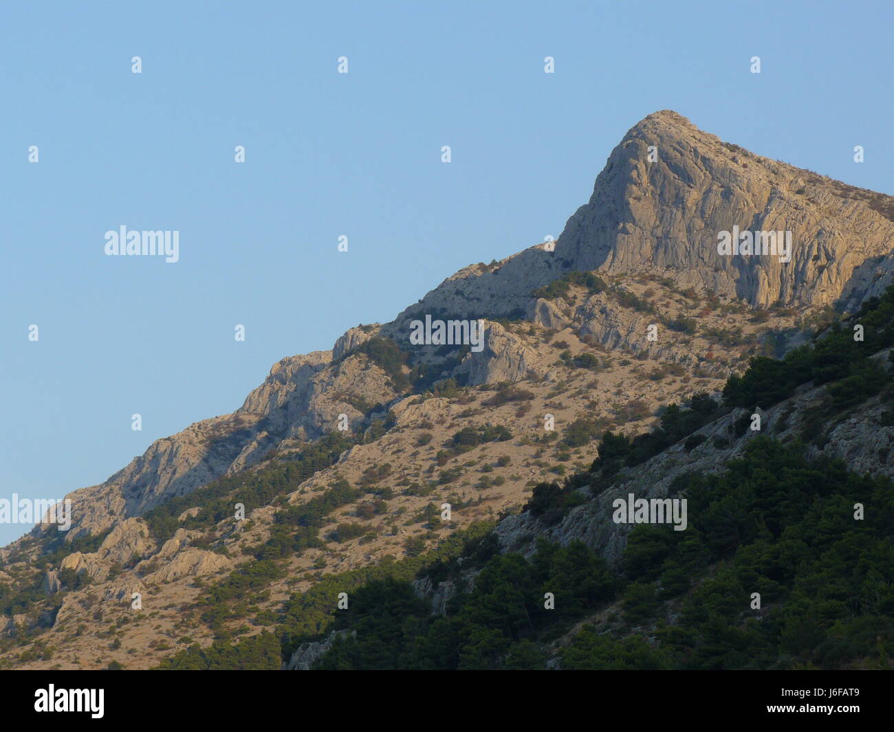 tip peak august sparse stinted mountain act of god rough shine shines bright Stock Photo