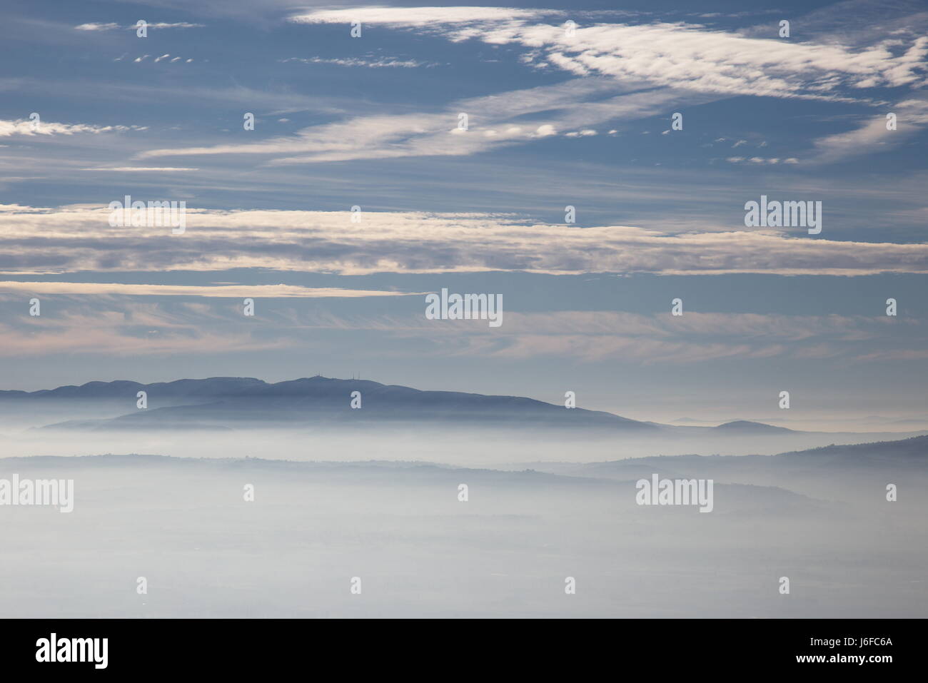 White clouds in a blue sky and fog below Stock Photo - Alamy