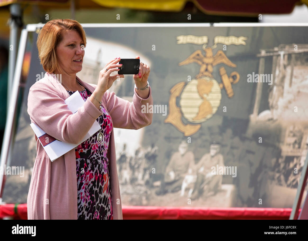 An attendee takes a picture of the display at the Centennial Celebration Ceremony at Lejeune Field, Marine Corps Base (MCB) Quantico, Va., May 10, 2017. The event commemorates the founding of MCB Quantico in 1917, and consisted of performances by the U.S. Marine Corps Silent Drill Platoon and the U.S. Marine Drum & Bugle Corps. (U.S. Marine Corps photo by James H. Frank) Stock Photo