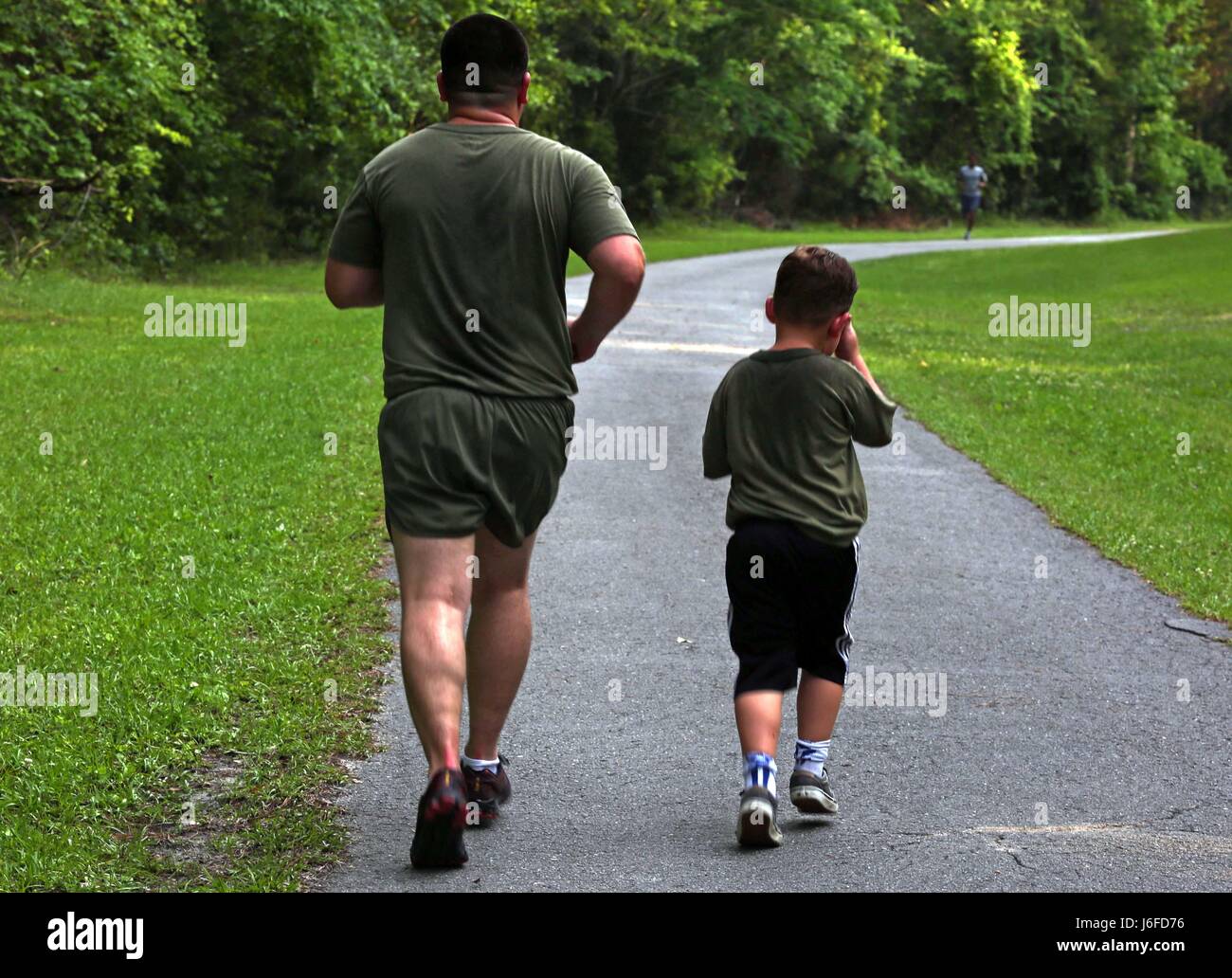 U.S. Marine Corps Staff Sgt. Albert Carls, left, combat videographer, Headquarters and Support Battalion, Marine Corps Installations East, and his son Tristan Carls, participate in a memorial run to honor fallen combat camera members, Camp Lejeune, N.C., May 11, 2017. Cpl. Sara Medina, a combat photographer, and Lance Cpl. Jacob Hug, a combat videographer, gave the ultimate sacrifice while providing humanitarian assistance and disaster relief to remote villages in Nepal in dire need of aid during Operation Sahayogi Haat. (U.S. Marine Corps photo by Lance Cpl. Kaitlynn M. Hendricks, MCIEAST Com Stock Photo