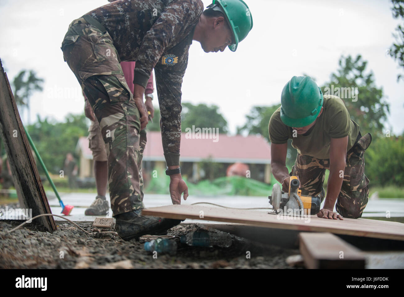Philippine Army Cpl. Jerwin Vic Jaballa, left, and Pfc. Joel Perez cut lumber during an engineering civic assistance project in support of Balikatan 2017 in Guiuan, Eastern Samar, May 11, 2017. Armed Forces of the Philippines and U.S. military engineers worked together to build new classrooms for students at Surok Elementary School. Balikatan is an annual U.S.-Philippine bilateral military exercise focused on a variety of missions, including humanitarian assistance and disaster relief, counterterrorism, and other combined military operations. (U.S. Navy photo by Mass Communication Specialist 2 Stock Photo
