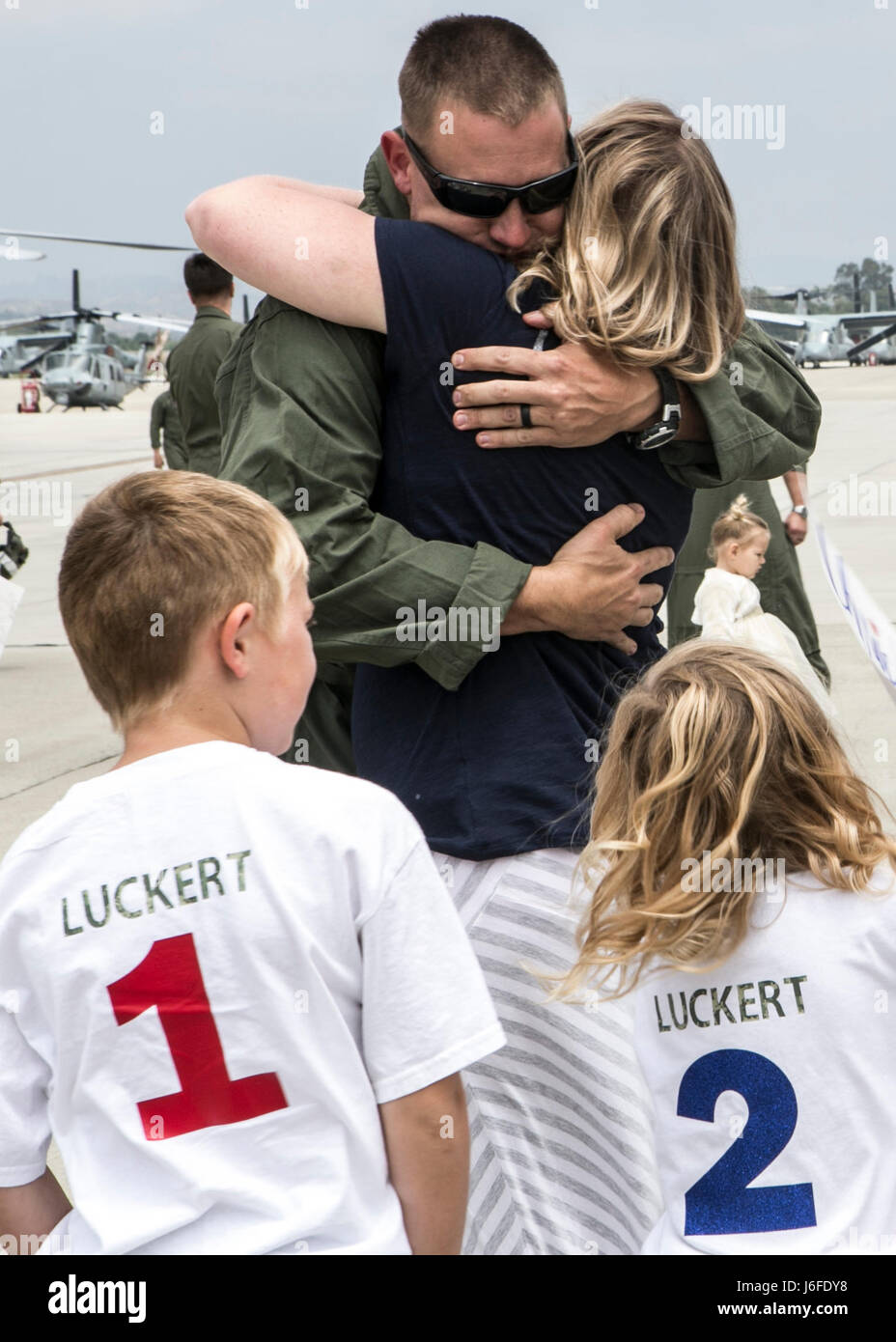 U.S. Marine Corps Staff Sgt. Christopher Luckert, a UH-1Y Venom AH-1Z Viper helicopter mechanic with Marine Light Attack Helicopter Squadron 369 (HMLA-369), 3d Marine Aircraft Wing, is reunited with his family after deployment a deployment with the 11th Marine Expeditionary Unit, on Marine Corps Camp Pendleton, Calif., May 12, 2017. Friends and family members welcomed home Marines from the 11th MEU’s Command Element during a homecoming ceremony. (U.S. Marine Corps photo by Lance Cpl. Clare J. Shaffer/Released) Stock Photo