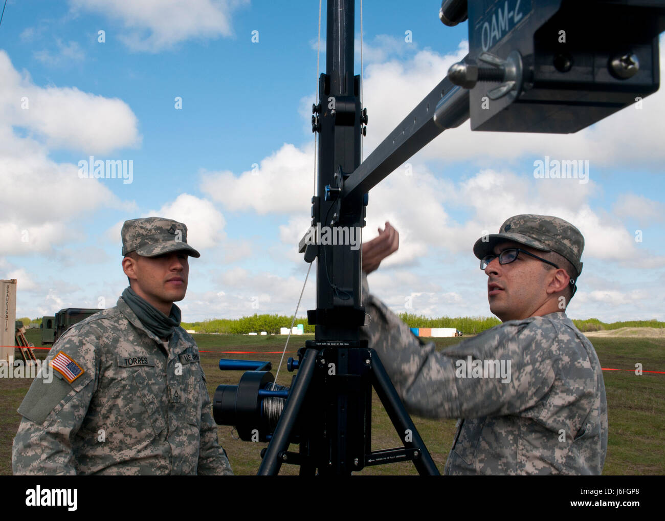 Pfc. Ismael Torres, a cable system installer maintainer, left, and Spc. Cody Gomez, a microwave system operator maintainer, prepare to raise a transmission antenna during Exercise Maple Resolve 17 at Camp Wainwright, Alberta, May 16, 2017. Torres and Gomez, both California natives, belong to the 306th Psychological Operations Company. Exercise Maple Resolve is an annual collective training event designed for any  contigency operation. Approximately 4,000 Canadian and 1,000 U.S. troops are participating in Exercise Maple Resolve 17. Stock Photo