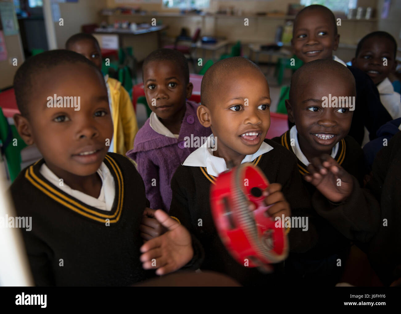 Students of the Kachikau Primary School play with a tambourine during a