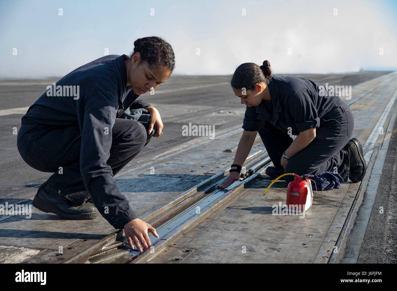 170517-N-QN175-029  ATLANTIC OCEAN (May 17, 2017) Aviation Boatswain's Mate (Equipment) Airman Kelli Williams, from Columbia, Md., left, and Aviation Boatswain's Mate (Equipment) Airman Alyessa Ramos, from Brooklyn, N.Y., right, lubricate nose gear during preservation procedures on the flight deck of the aircraft carrier USS Dwight D. Eisenhower (CVN 69) (Ike). Ike is currently underway conducting engineering drills as part of the sustainment phase of the Optimized Fleet Response Plan (OFRP). (U.S. Navy photo by Mass Communication Specialist 3rd Class Dartez C. Williams) Stock Photo