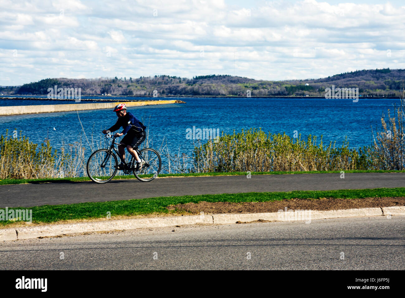 Marquette Michigan Upper Peninsula UP Lake Superior,Lakeshore Boulevard,Bicycle Path,breakwater,Great Lakes,early spring,man men male,bicycle,bicyclin Stock Photo