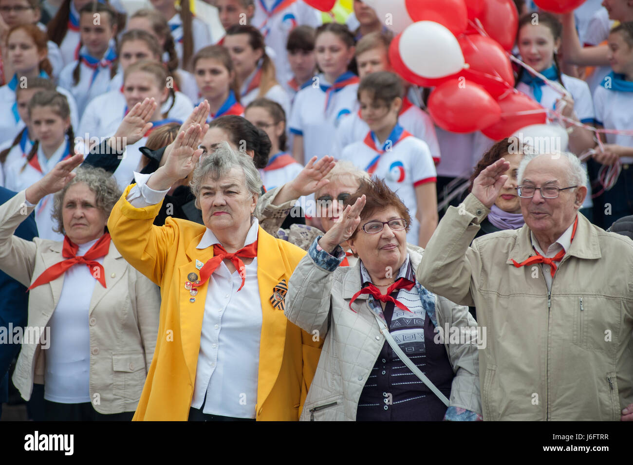 Tambov, Tambov region, Russia. 21st May, 2017. Older people in pioneer ties of the USSR times give pioneer greeting (pioneer salute). In the background of the modern pioneers of Russia - representatives of the ''Russian movement of students' Credit: Aleksei Sukhorukov/ZUMA Wire/Alamy Live News Stock Photo