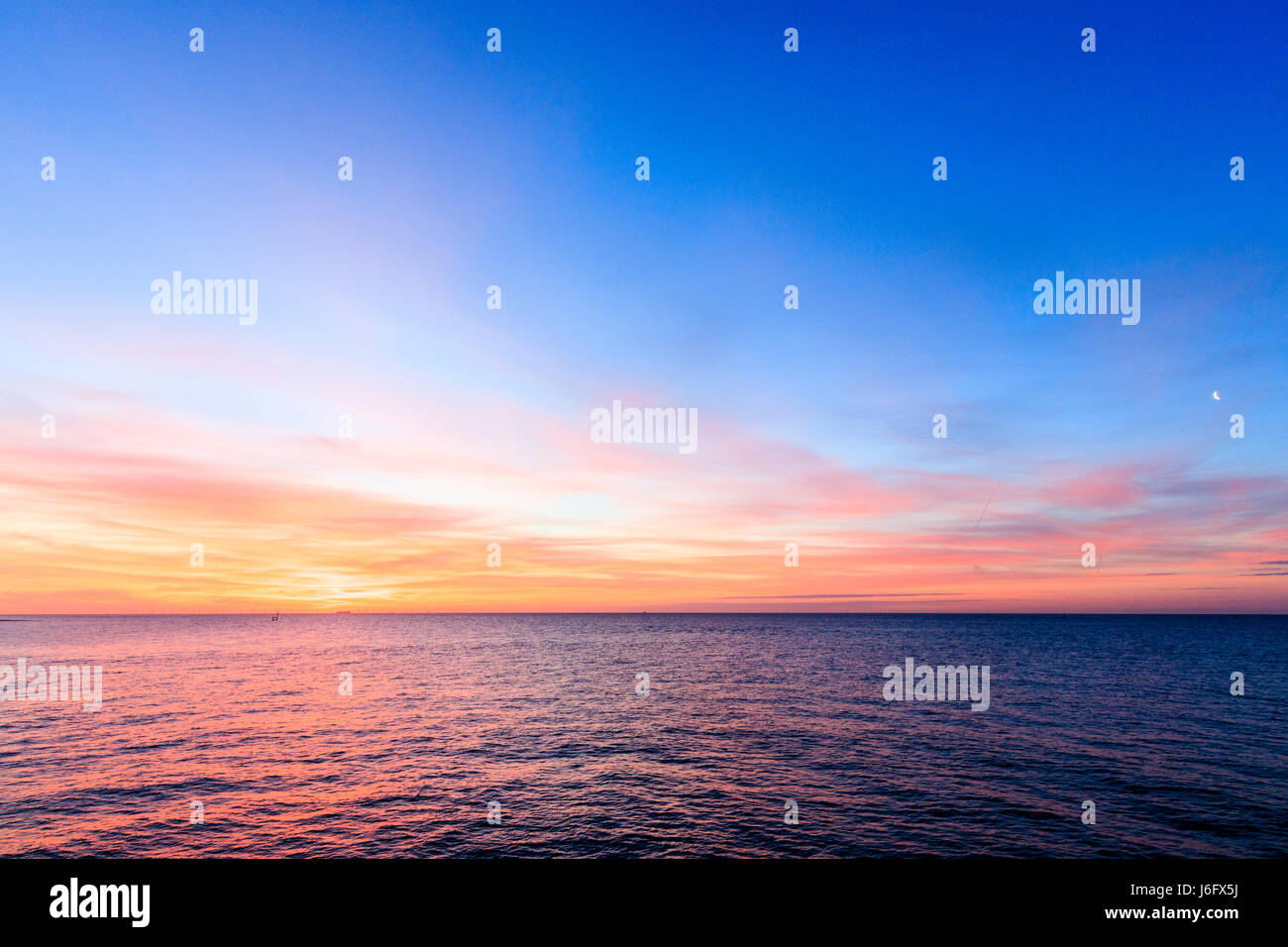 Wide Angle Dawn Sky With A Crescent Moon Over The English Channel On Horizon Is The Thanet Offshore Wind Farm Sky Is Orange And Yellow On Horizon Then Turning To Blue And