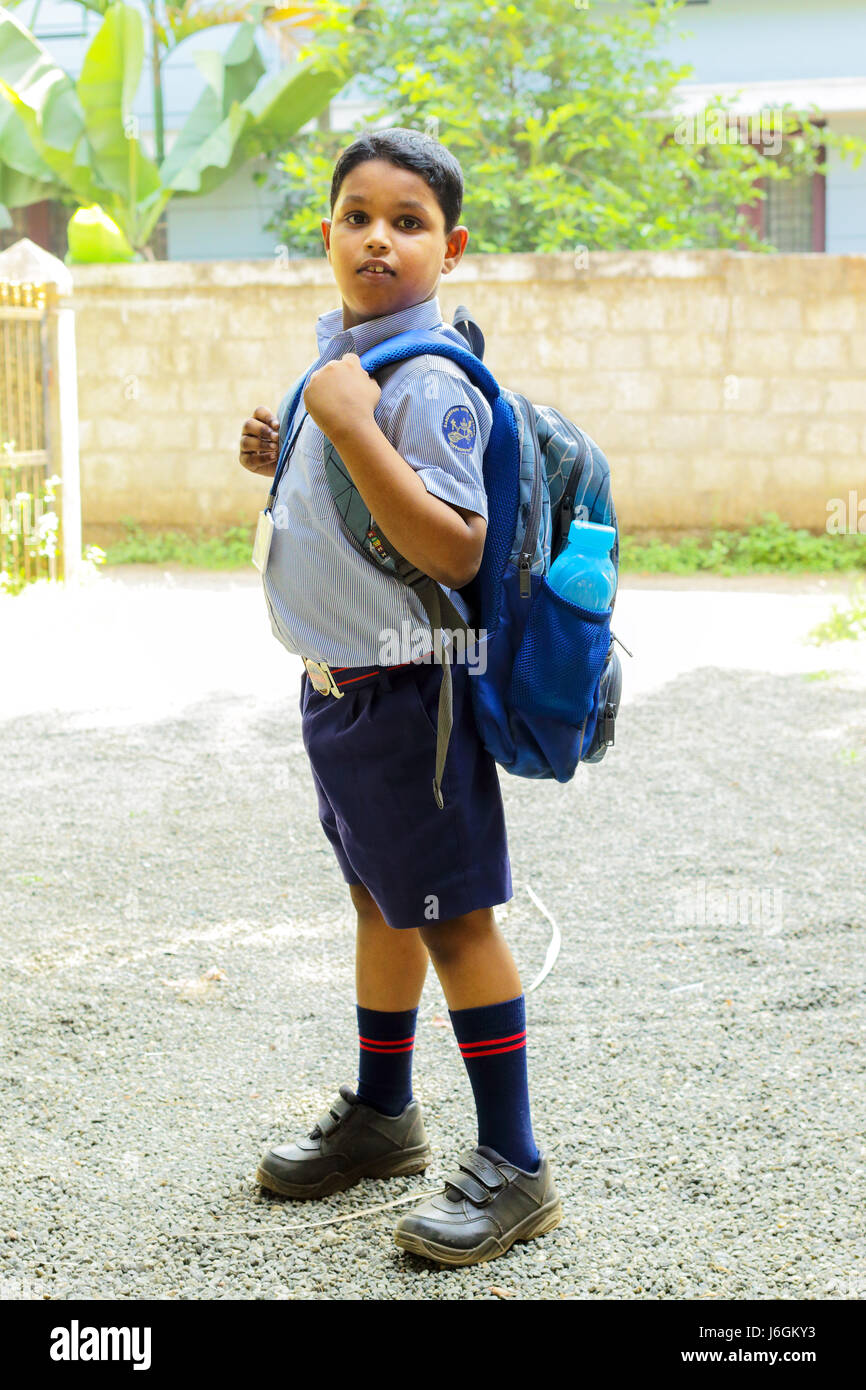 indian school kid ready to go school wearing uniform and school bag,thrissur,kerala,south india,asia,child in school uniform,PRADEEP SUBRAMANIAN Stock Photo