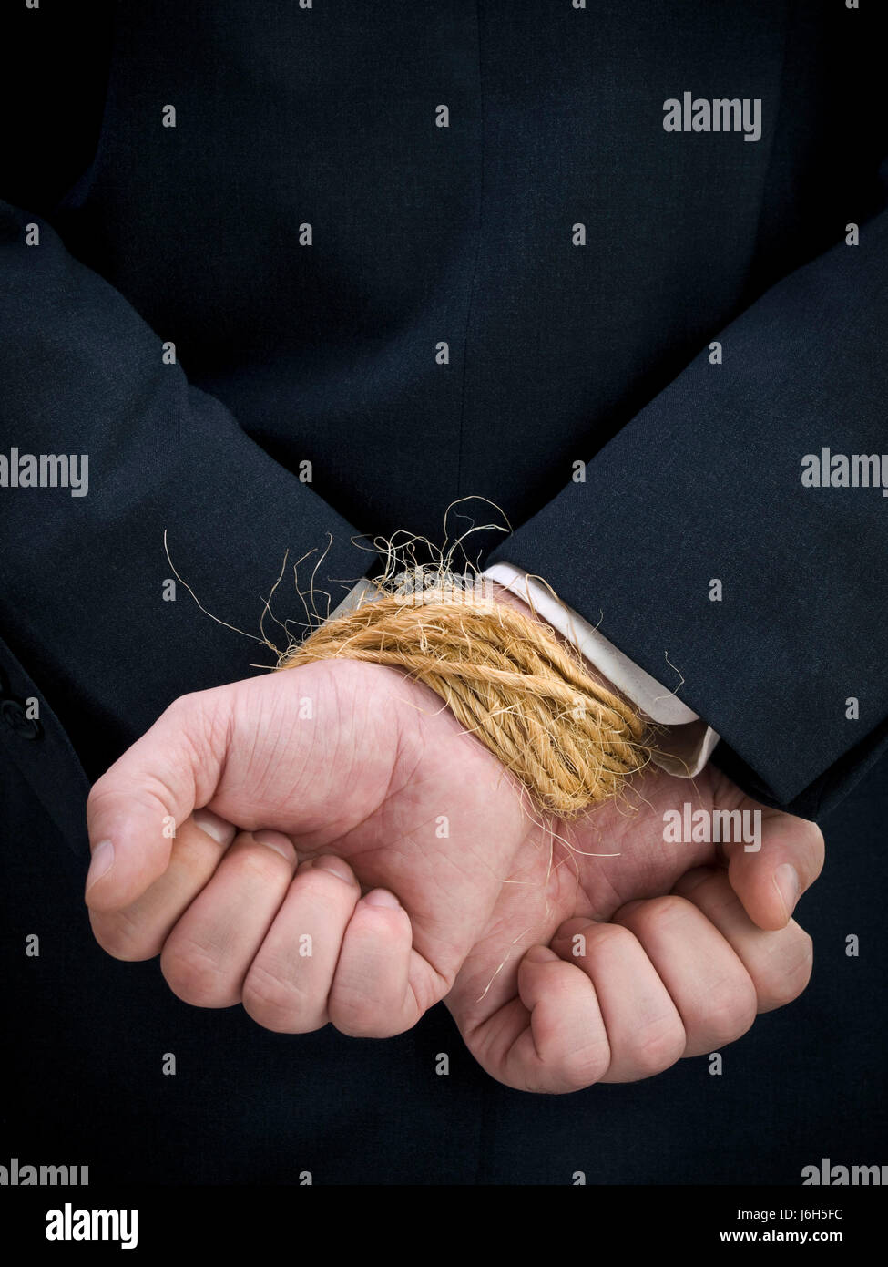hand hands business man businessman bound tied back held rope suit guy close Stock Photo