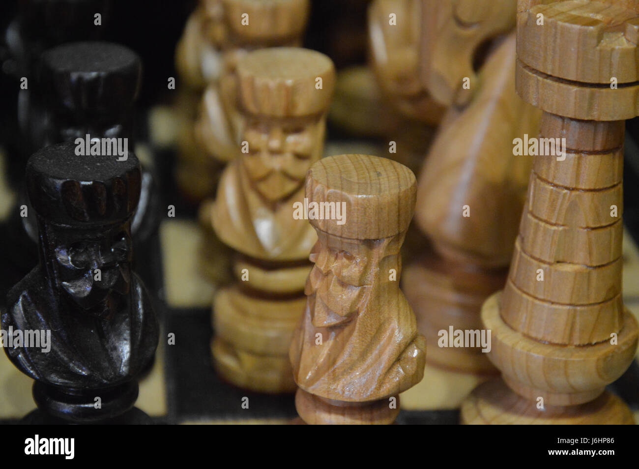 Carved chess pieces on a board, close-up. Stock Photo