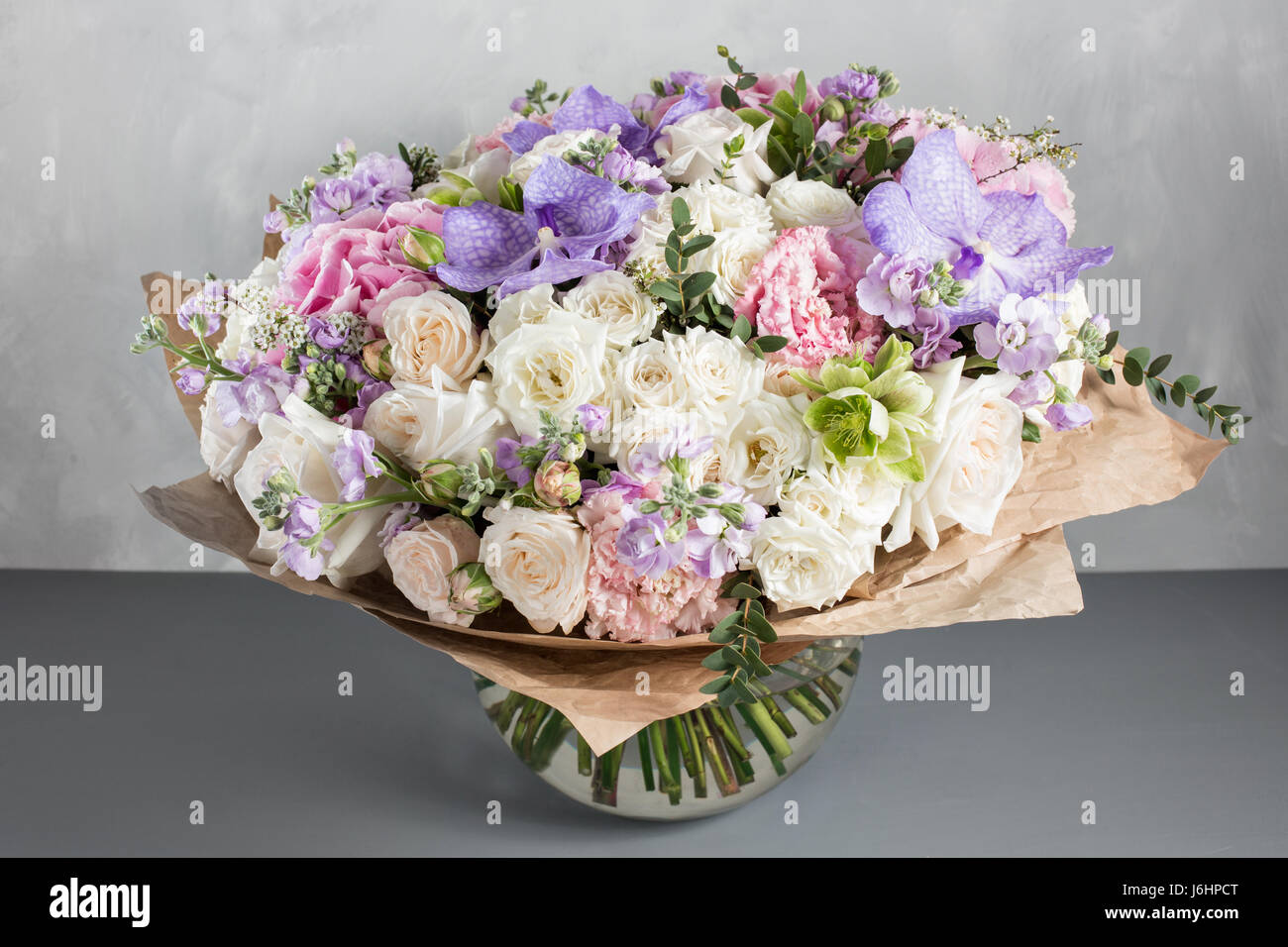 luxurious and elegant bouquet of roses and Other colors flowers on wooden gray background, copy space. Stock Photo
