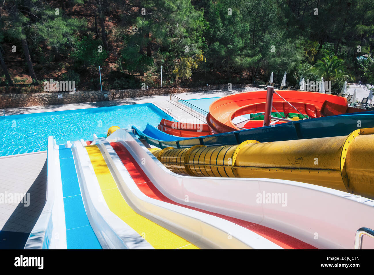 Colorful aquapark in green forest. Summer attraction in sea resort Stock Photo
