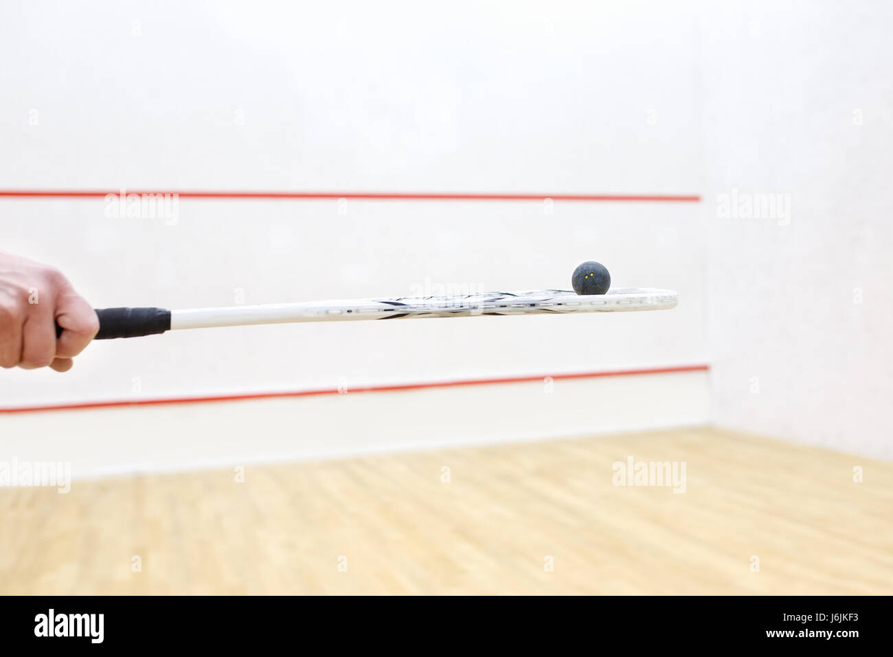 hand holding squash racket and ball. Racquetball equipment. Photo with