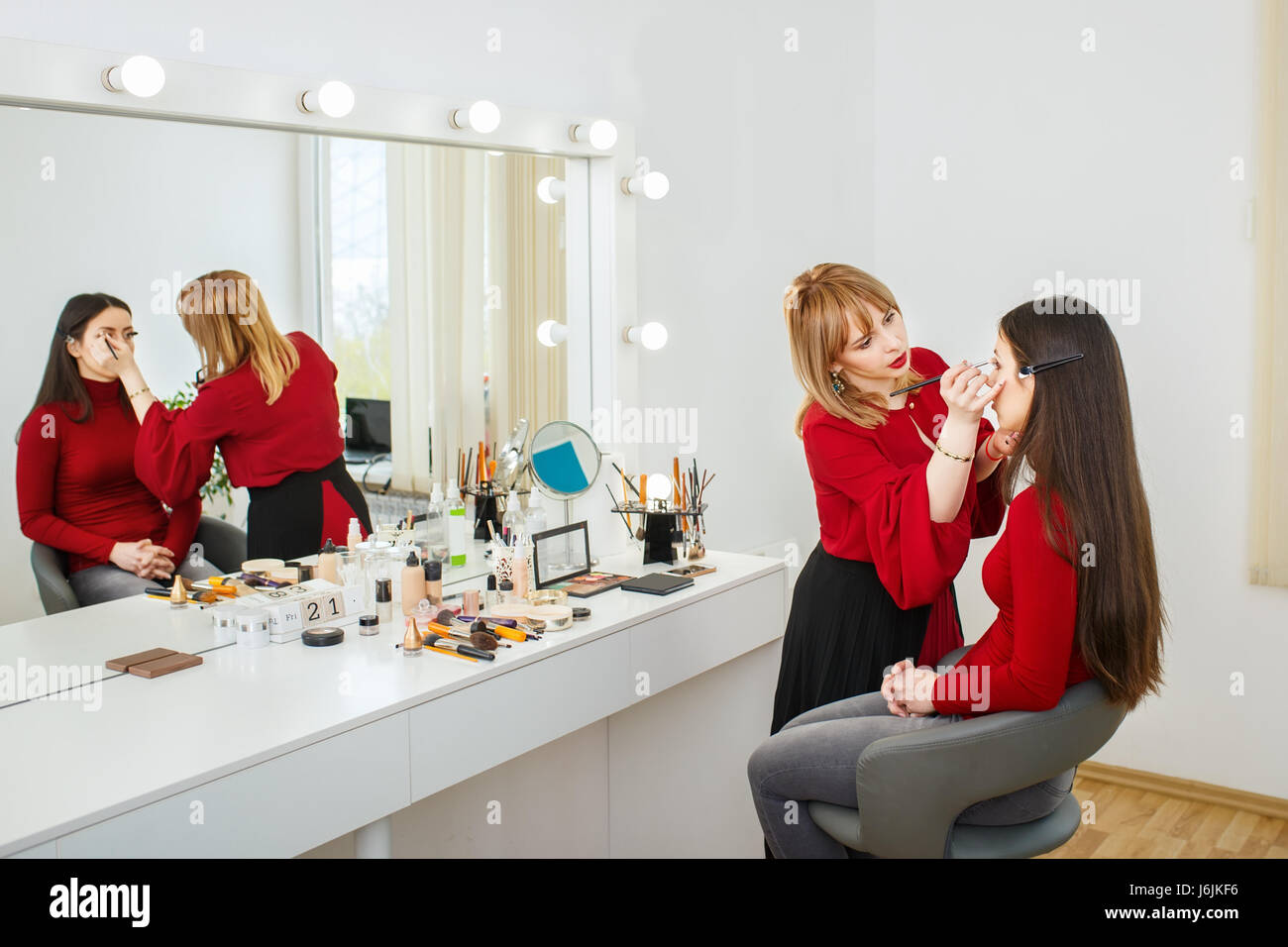 professional makeup artist doing makeup for young woman. Make-up artist at  work in beauty salon. Backstage photo as visagiste applying makeup Stock  Photo - Alamy