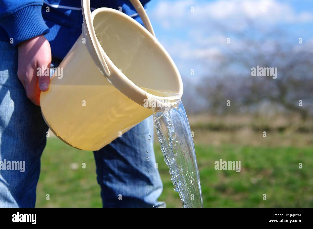 water is poured from a bucket Stock Photo