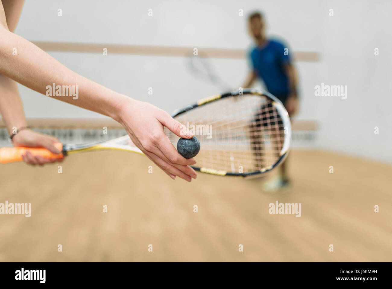 Young couple with rackets play squash game in indoor training club