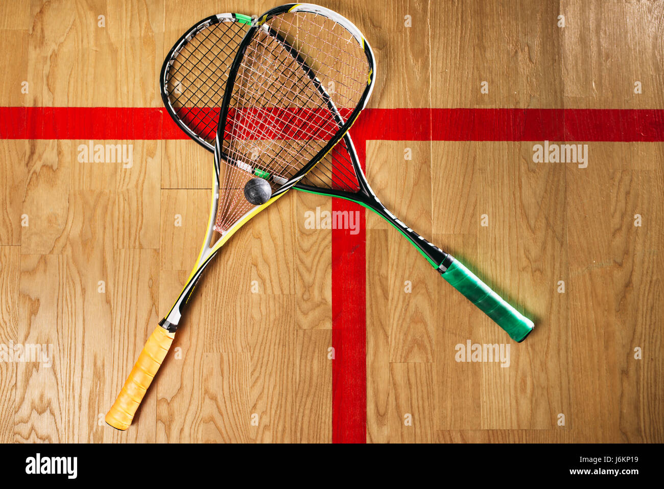 Squash game equipment closeup view. Rackets and ball on the floor in