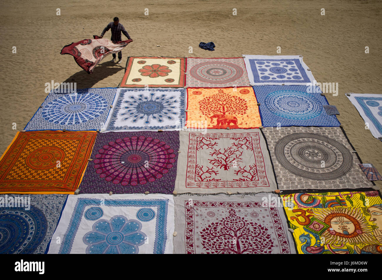 A street vendor places beach blankets at the maritime district of La Barceloneta in Barcelona. Stock Photo