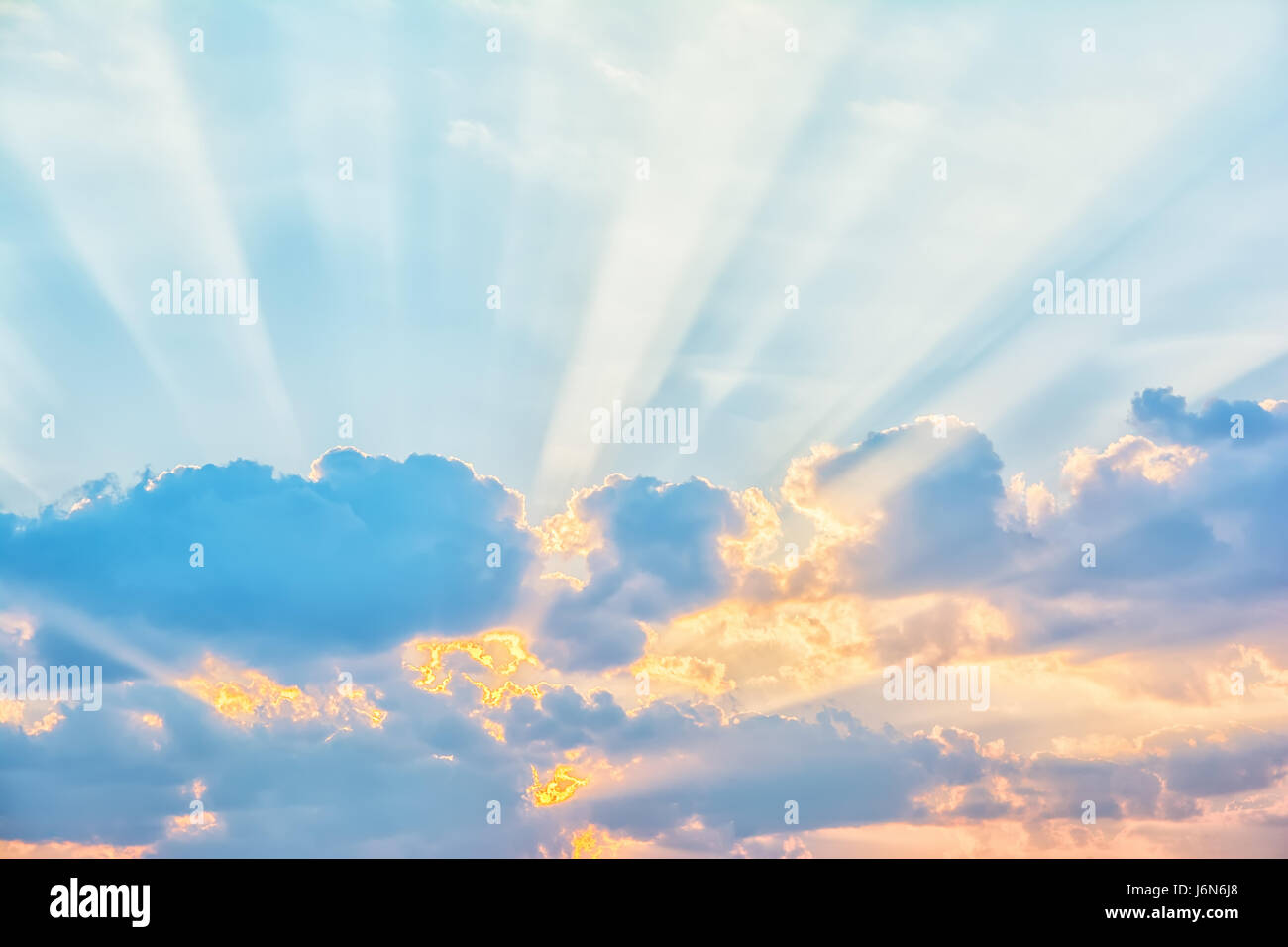 Sunrise sky with sun rays breaking through the clouds Stock Photo